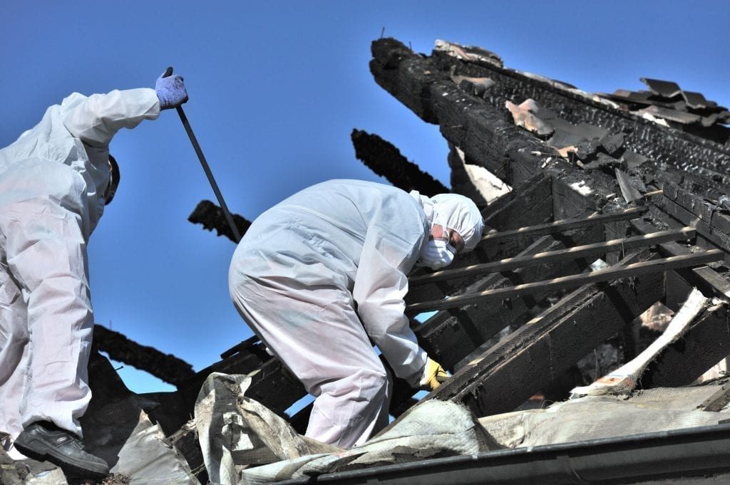 SES Class A asbestos removal crew working in full PPE on an Auckland commercial roof