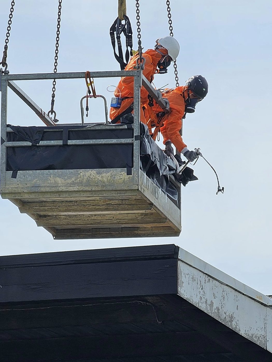 SES operative removing asbestos roofing sheets from a work platform, Auckland