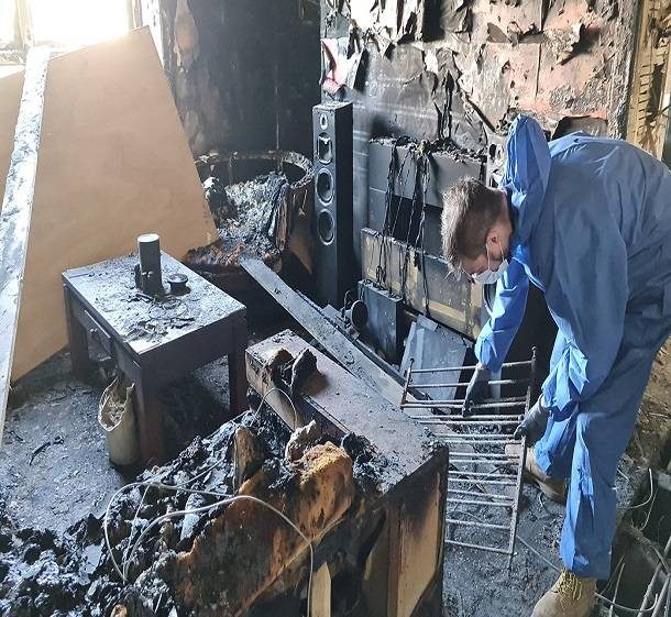 Technician cleaning soot from a fire-damaged kitchen