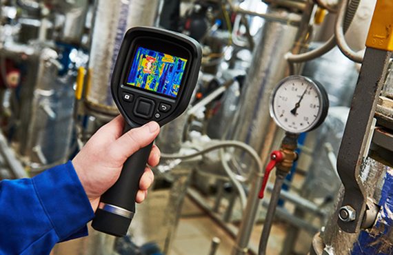 Thermal imaging camera locating moisture behind a wall during leak detection