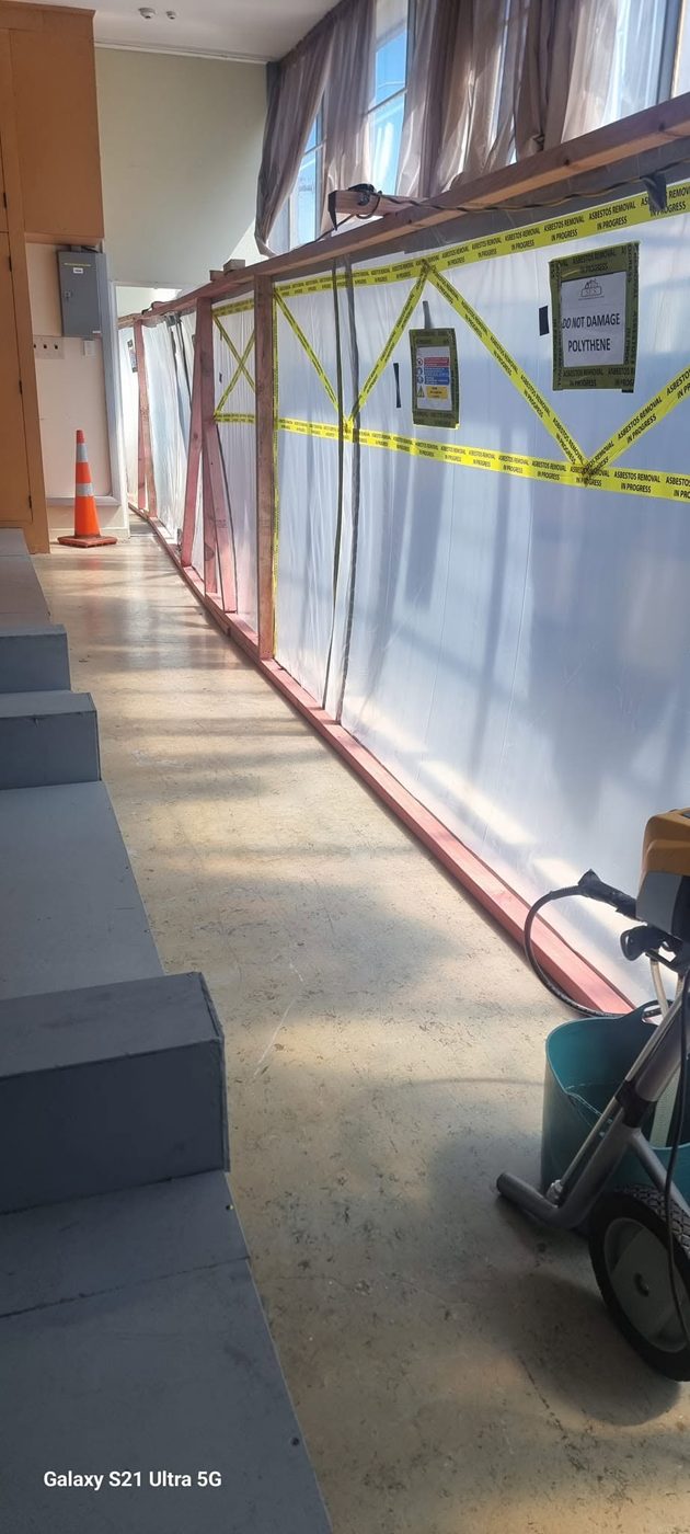 Negative-pressure enclosure along an office corridor for AIB asbestos insulation board removal