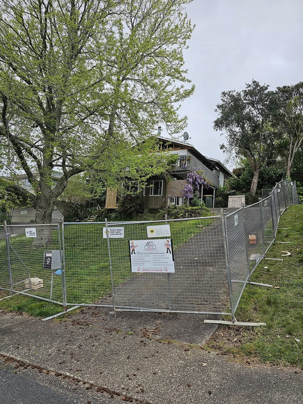 Security fence and SES hoarding around a residential demolition site in Auckland