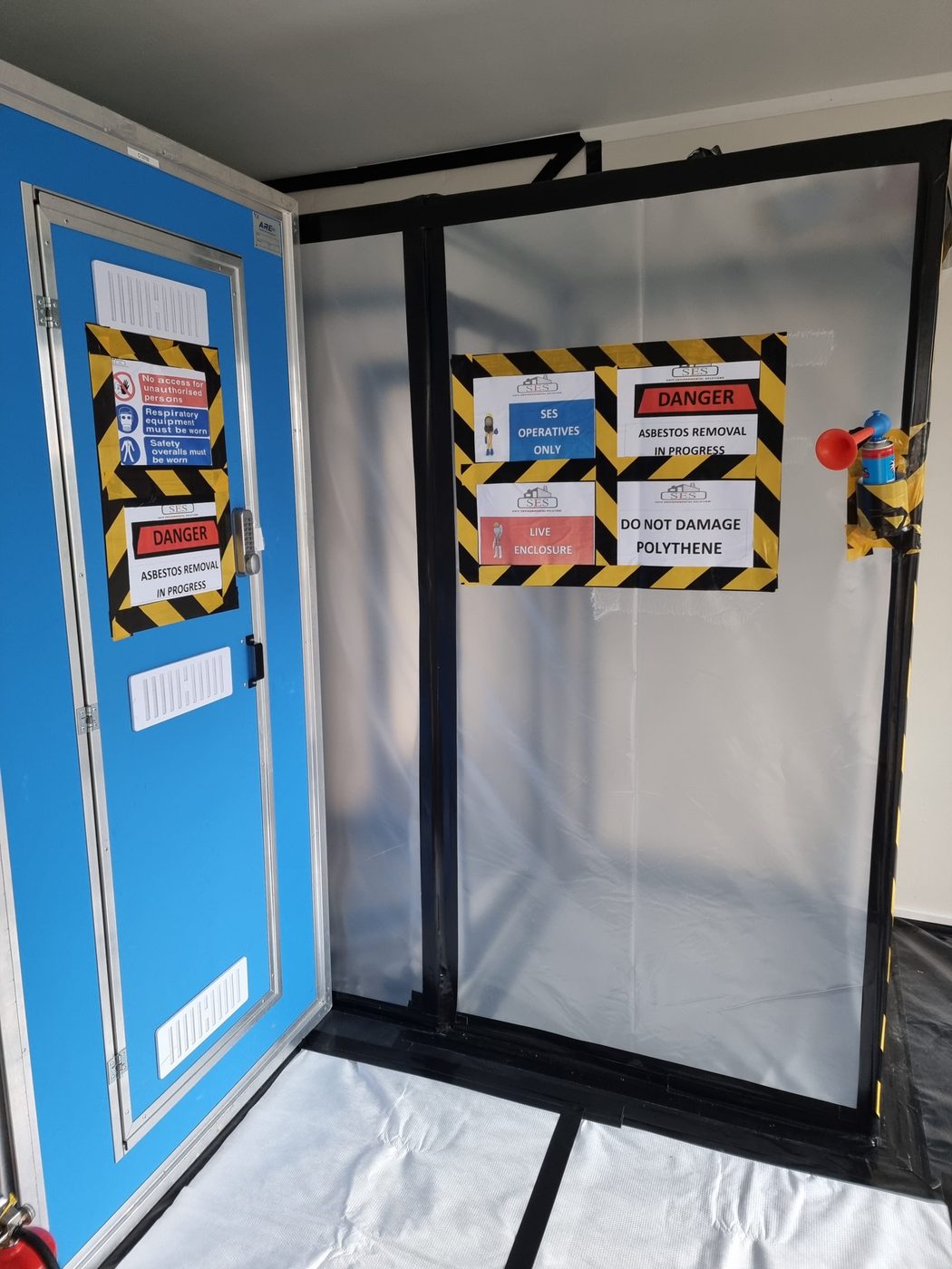 SES Asbestos crew setting up a negative-pressure enclosure on a commercial site