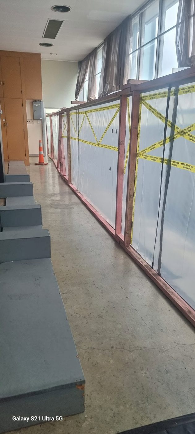 Glazed office partitions sheeted for removal during an SES soft-strip